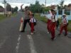 Bhabinkamtibmas Polsek Utan Berikan Pelayanan Prima dengan Membantu Anak-Anak Sekolah Menyeberang Jalan